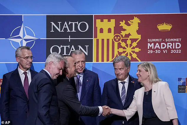 Turkish Foreign Minister Mevlut Cavusoglu, third from the left, shakes hands with Swedish Prime Minister Magdalena Andersson, right, next to Turkish President Recep Tayyip Erdogan, center, and Finnish President Sauli Niinisto, second from the right, after signing a memorandum in which Turkey agrees to Finland and Sweden joining NATO; NATO Secretary General Jens Stoltenberg (left) looks on.